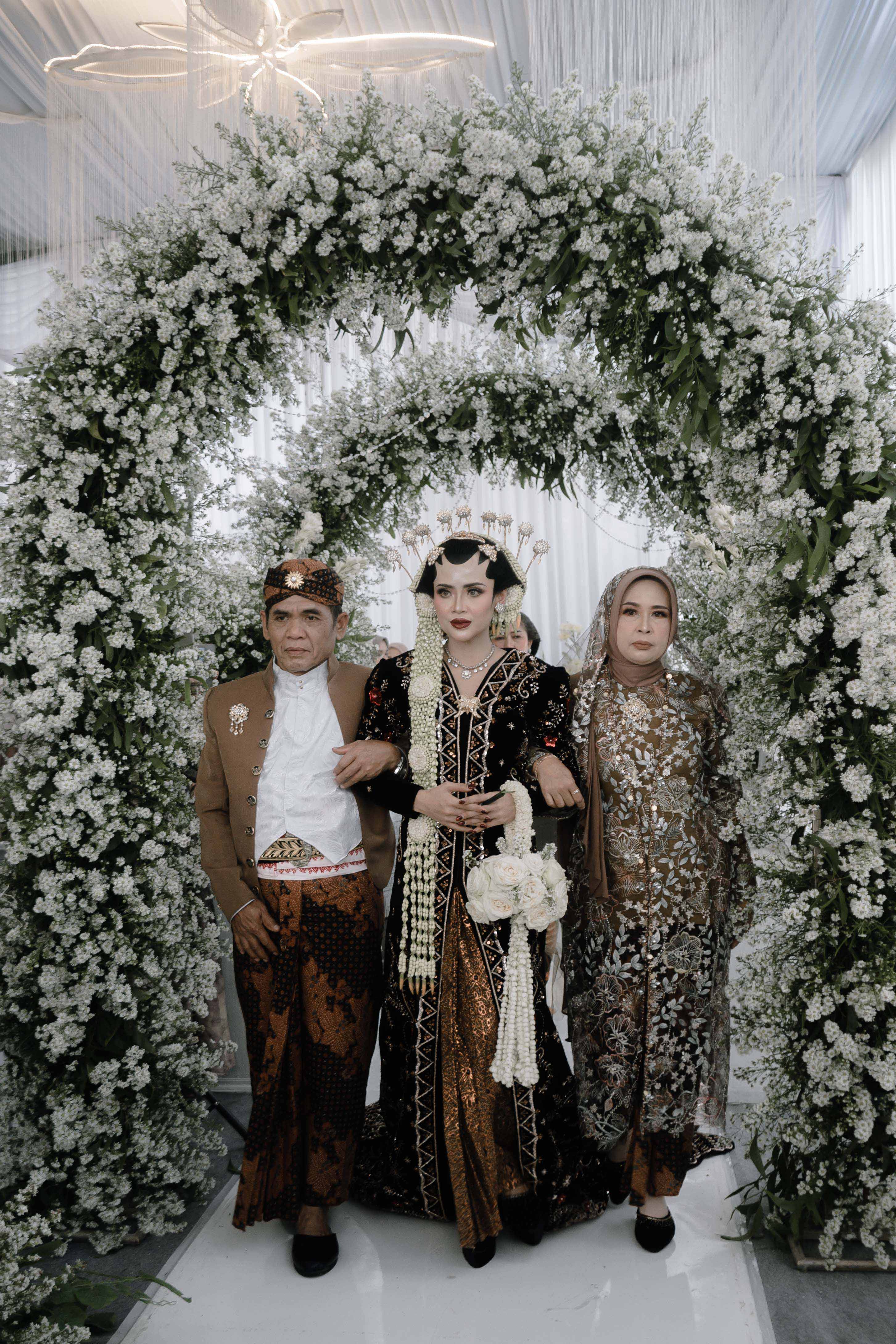 Keluarga dan tamu menyaksikan acara pernikahan